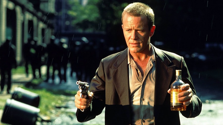 A flawed hero, whiskey in hand.