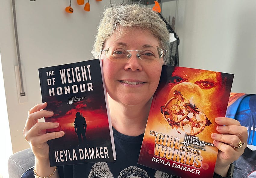 Keyla Daemer with two of his science fiction novels. 